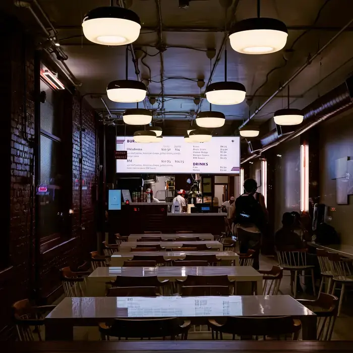 The dining room with long tables under hanging lamps